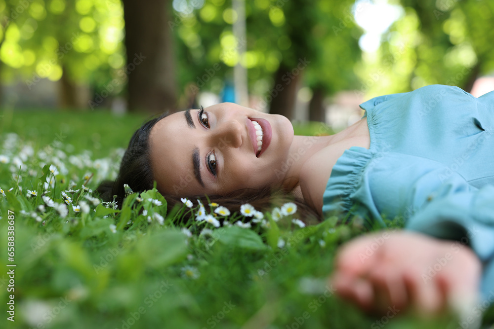 Beautiful woman lying on green grass in park. Spring sunny day Beautiful woman lying on green grass in park. Spring sunny day