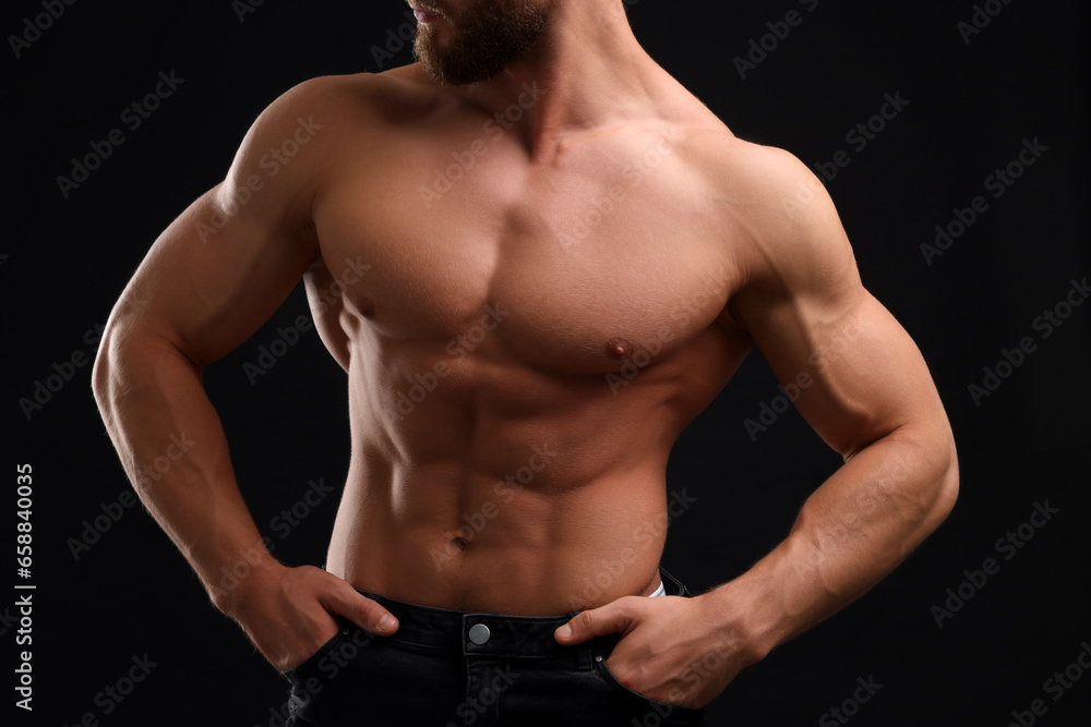 Muscular man showing abs on black background, closeup. Sexy body