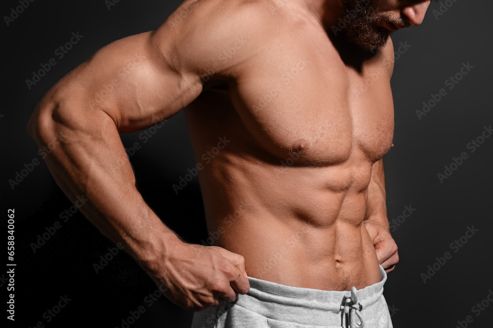 Muscular man showing abs on black background, closeup. Sexy body Muscular man showing abs on black background, closeup. Sexy body