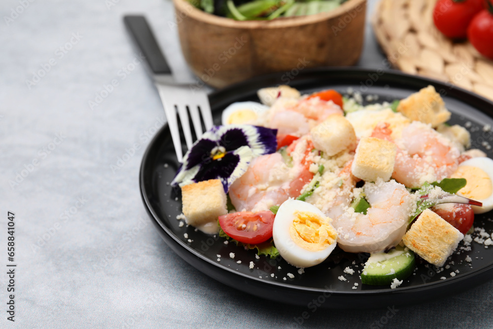 Delicious Caesar salad with shrimps served on grey table, closeup Delicious Caesar salad with shrimps served on grey table, closeup