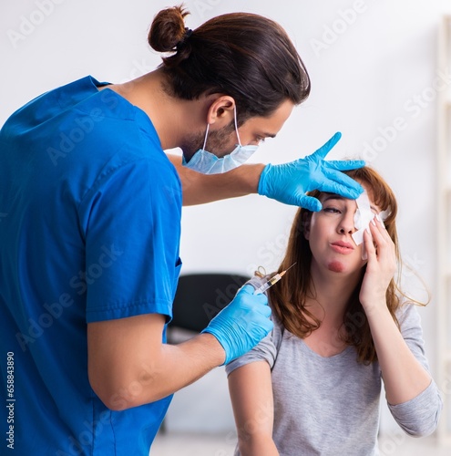 Young head injured woman visiting young male doctor
