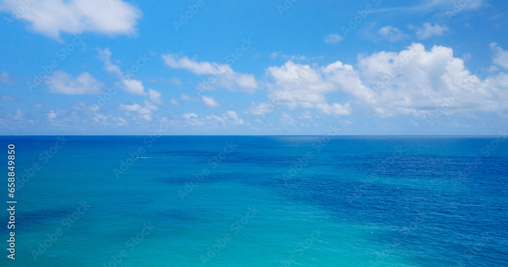 4K Aerial view Blue sky with white clouds moving panorama summer. Sea in light of day aerial view of drone slide forward. Small waves on sea. Sunny sunny over the sea.