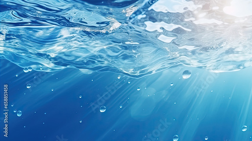 Blurry blue water surface with bubbles and splashes Nature background with sunlight and space for text