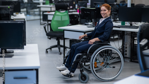 Caucasian woman wheelchair in open space office.