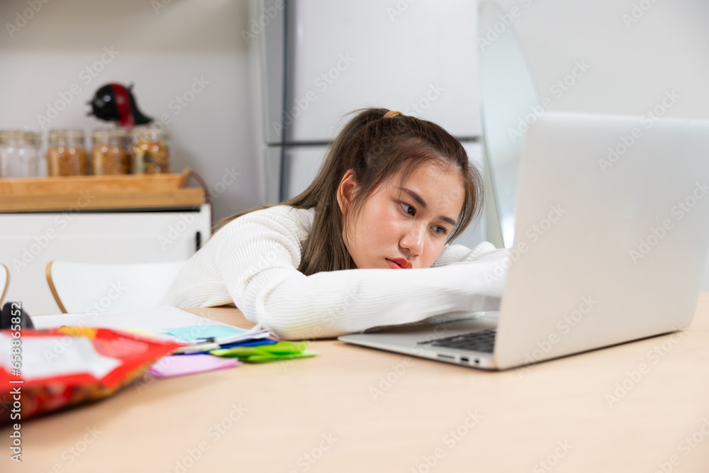 Tired exhausted, fatigue and fell asleep. Yaoung asian thai female working on laptop in kitchen room at home. Overwork. Exhausted woman sleeply eye at workplace Tired exhausted, fatigue and fell asleep. Yaoung asian thai female working on laptop in kitchen room at home. Overwork. Exhausted woman sleeply eye at workplace