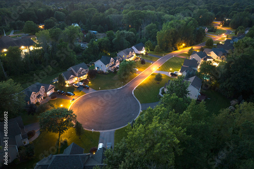 Behang Aerial night view cul-de-sac road and spacious illuminated family houses in upstate New York suburban area
