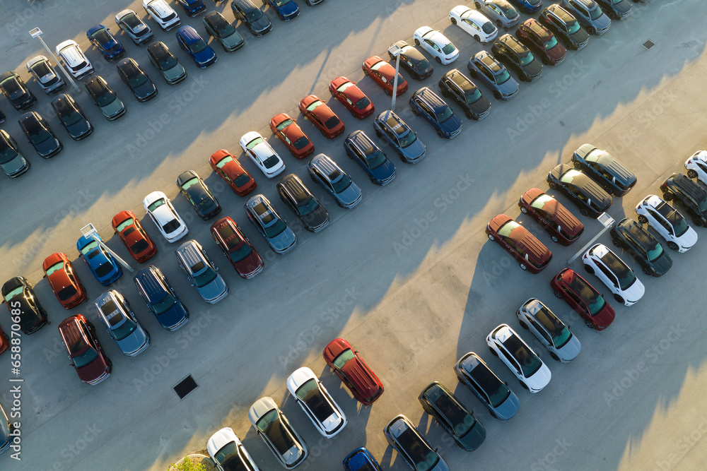 Fototapeta premium Large parking lot of local dealer with many brand new cars parked for sale. Development of american automotive industry and distribution of manufactured vehicles concept