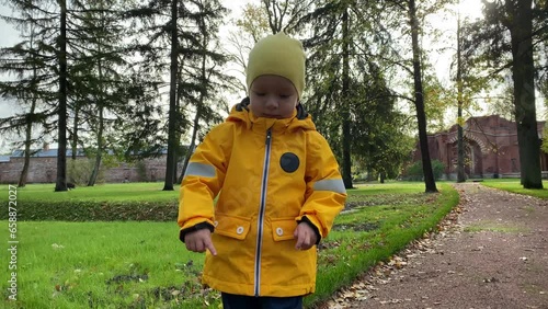 toddler child little boy in a yellow jacket walking playing in autumn park. Aleksandrovsky Park, Pushkin, St. Petersburg, Russia. photo