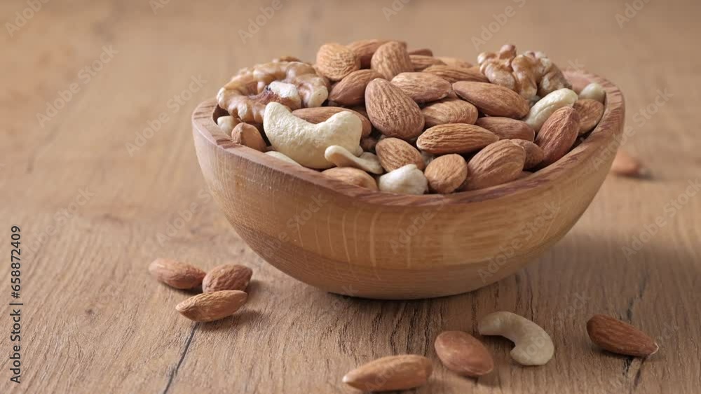 Assorted nuts of almonds, cashews, and walnuts in a wooden bowl. Healthy nutrition concept. Assorted nuts of almonds, cashews, and walnuts in a wooden bowl. Healthy nutrition concept.