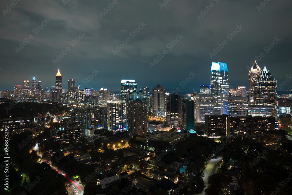 View from above of brightly illuminated high skyscraper buildings in downtown district of Atlanta city in Georgia, USA. American megapolis with business financial district at night