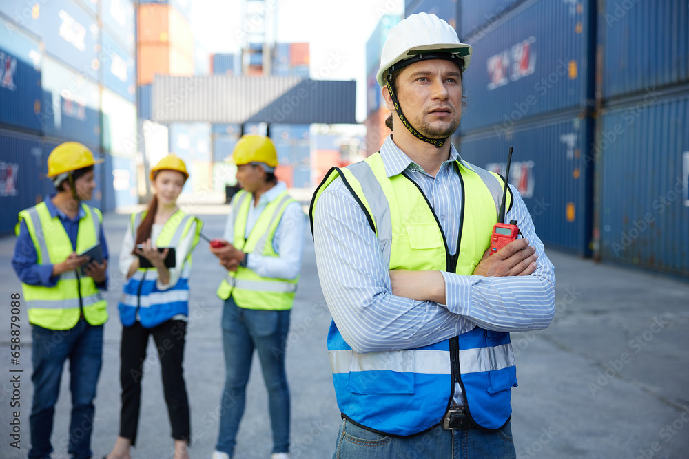 factory worker or engineer holding walkie talkie and folded arms pose in containers warehouse storage factory worker or engineer holding walkie talkie and folded arms pose in containers warehouse storage
