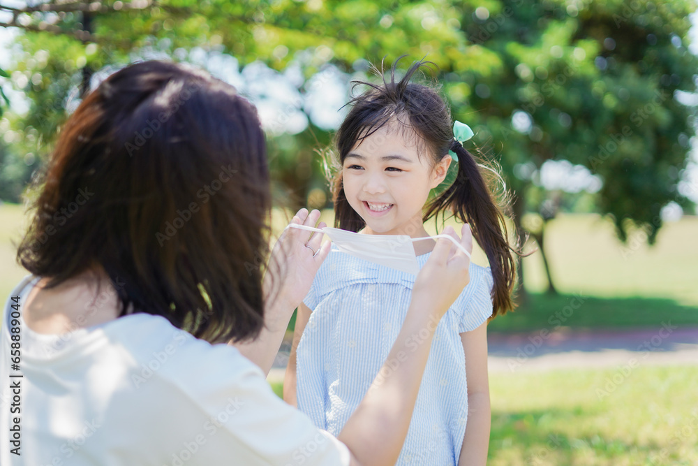 子どもにマスクを付けさせるお母さん