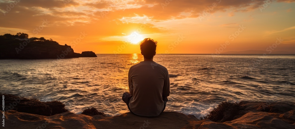 Fototapeta premium Man watching sunset over the sea With copyspace for text