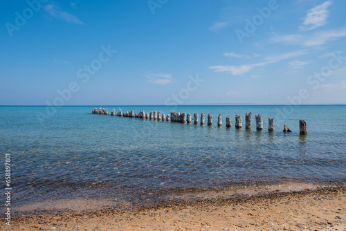 Clear blue waters of Lake Superior  with rocky beach and wooden pier.
