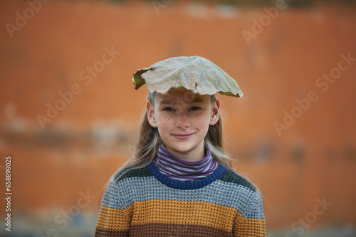 smiling girl with autumn leaf on her head