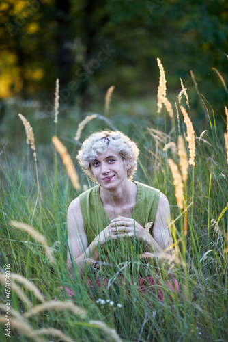 smiling young man sitting in the grass