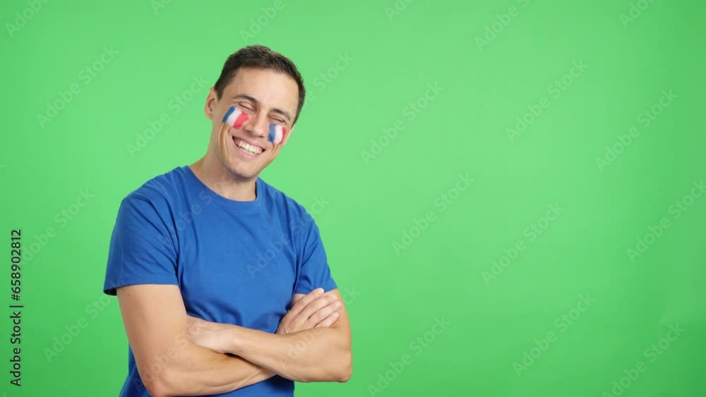 Happy man with french flag painted on face looking away Happy man with french flag painted on face looking away