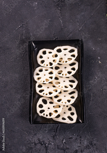 l exotic lotus root on a black plate. Garnish. View from above. Chinese cuisine, hotpot ingredient
