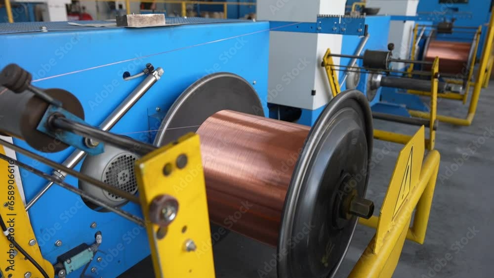 Rotating reels with copper wire on them. Metal wire spool spins on the machine. Production of copper wire, cable in reels at factory. Cable factory.
Rotating reels with copper wire on them. Metal wire spool spins on the machine. Production of copper wire, cable in reels at factory. Cable factory.