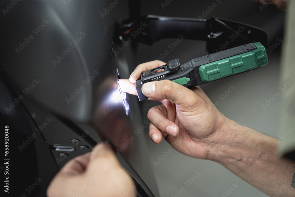 Replacing spare parts on a disassembled car in a car service garage