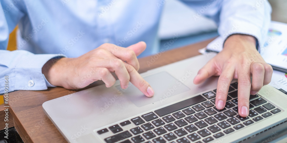 Close-up freelance businessman working at indoors home office typing hand on desk computer laptop internet communication technology, human hand adult business person using laptop keyboard notebook Close-up freelance businessman working at indoors home office typing hand on desk computer laptop internet communication technology, human hand adult business person using laptop keyboard notebook