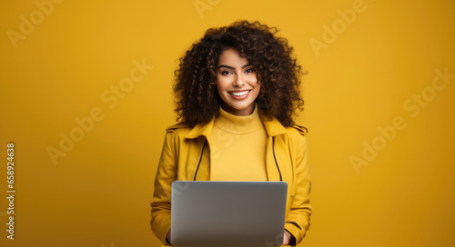 Selfassured Woman On Isolated Background Young Woman Holding Laptop On Vibrant Yellow Studio Background . Сoncept Self-Confidence, Independence, Digital Technology, Creativity photo