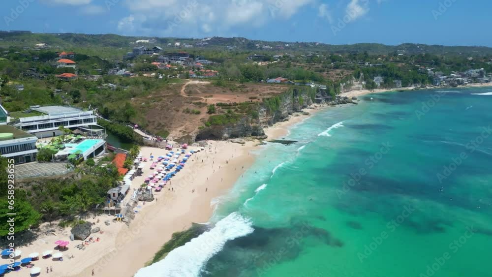 Beautiful tourist beach in southern Bali. Dreamland beach and the ocean with surfers riding these impressive waves in a crystal clear sea. Beautiful tourist beach in southern Bali. Dreamland beach and the ocean with surfers riding these impressive waves in a crystal clear sea.
