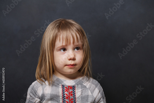 Cheerful little child girl on blackboard background