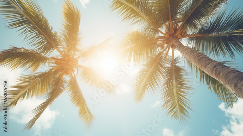 A vintage-style view from below captures blue skies and palm trees, creating a tropical beach and summer background that embodies the essence of travel © Vlad