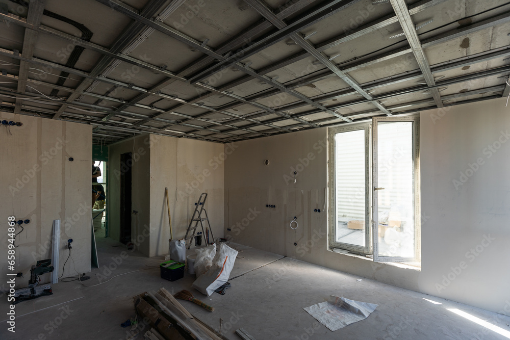 Drywall installation work in progress by construction workers at