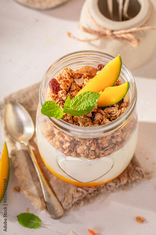 Homemade and delicious mango granola in jar with oat flakes. Homemade and delicious mango granola in jar with oat flakes.