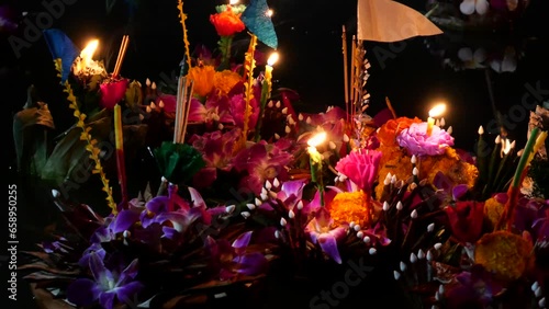 Krathongs floating on the water. Loy Krathong Festival (Festival of Lights) in Thailand. The celebration is used to show respect and thanks to the Goddess of water by using krathongs.  photo