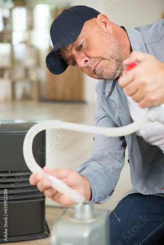 auto mechanic holding a pipe with oil