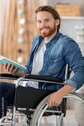 man reading a book sat in a wheelchair