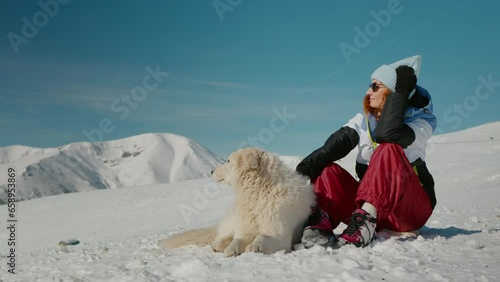 Female explorer petting her dog while admiring surroundings in the mountainsin winter. Best friendish ever human and the dog. photo