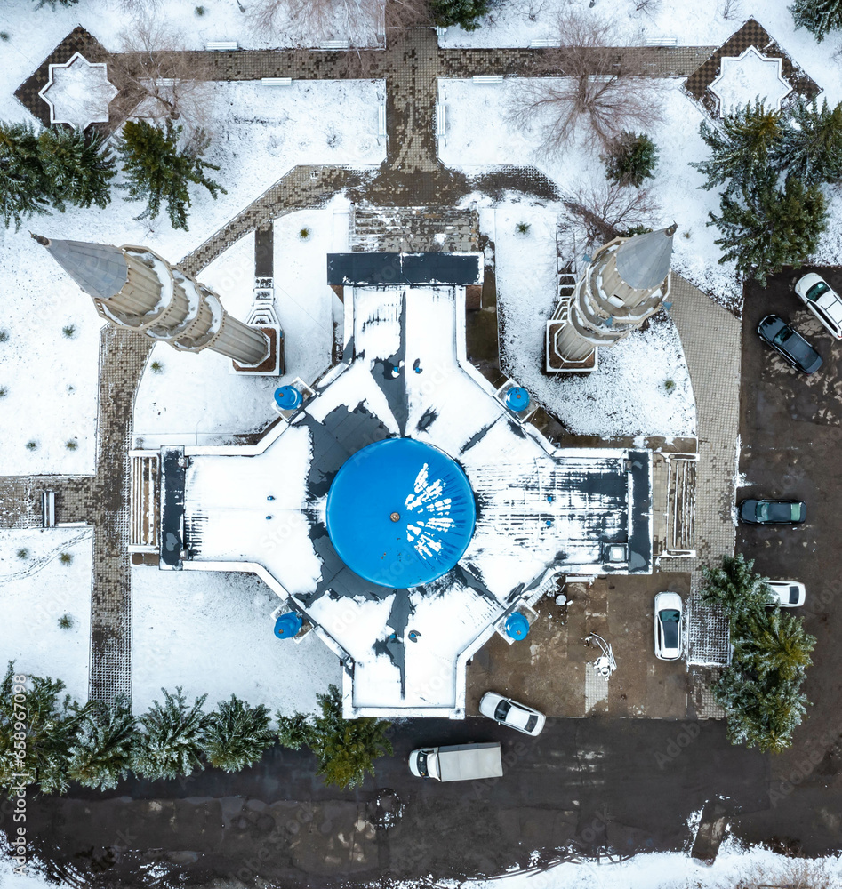 flying vertically down on drone over a mosque with blue dome, winter Kazakhstan city, Ust Kamenogorsk