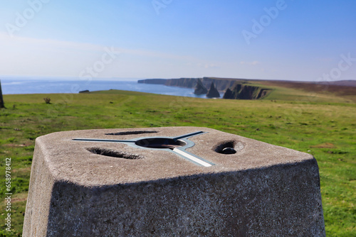 Trig point at duncansby stacks on the north coast 500 in scotland photo