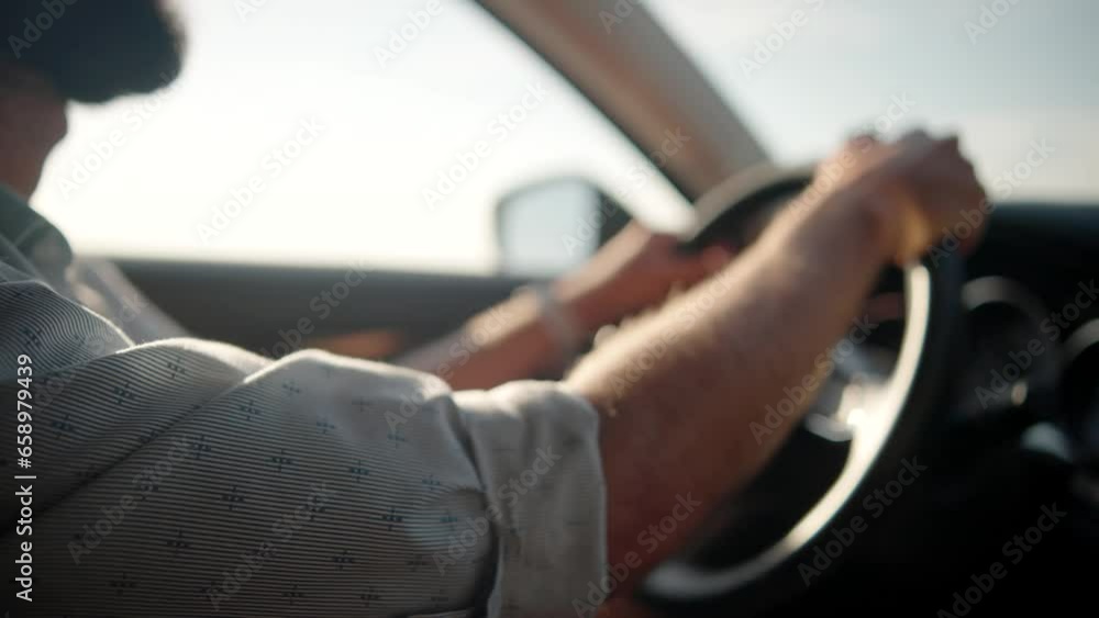 Driver holds steering wheel, enjoying road trip Driver holds steering wheel, enjoying road trip