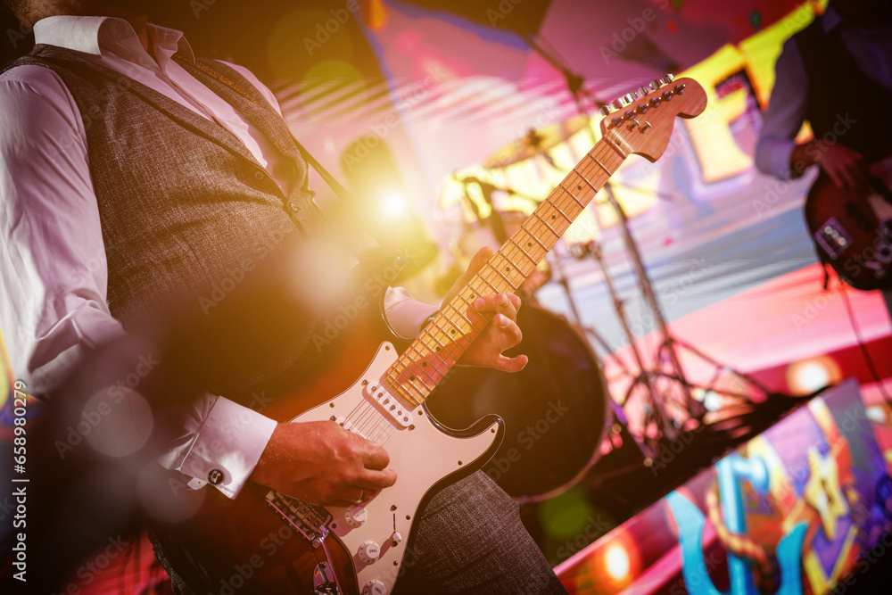 Obraz premium A close-up shot of a guitarist playing their guitar live on stage.