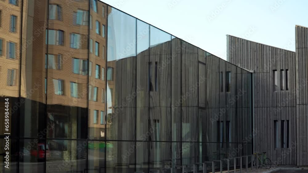 View of the glazed facade constructions with ultraviolet protection in modern architecture. Wood, glass, metal, and bricks are used as structural elements in construction with a decorative finish. View of the glazed facade constructions with ultraviolet protection in modern architecture. Wood, glass, metal, and bricks are used as structural elements in construction with a decorative finish.
