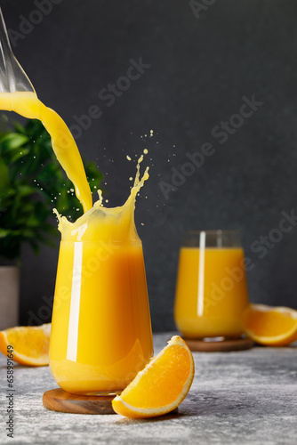Foto orange juice pouring into glass with splash on table