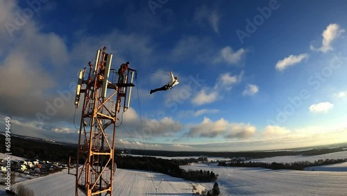 jump from a height, jump from a tower with belay, a girl jumps from a height with belay, a woman jumps from a tower with belay, 
Slow motion photo