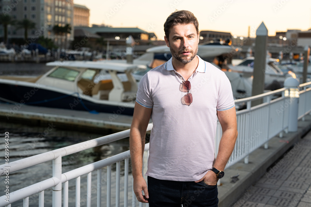 Fototapeta premium Urban style guy with casual clothes walk in Tampa city. Portrait of attractive man with casual clothes walk in American city. Handsome young man in an urban fashion lifestyle walking in the street.