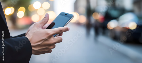 Businessman using his smartphone in city