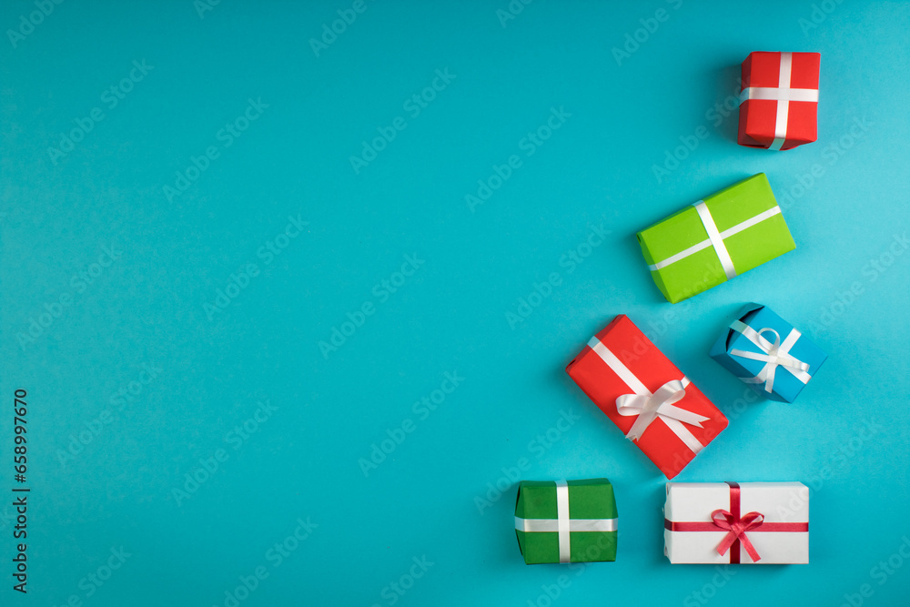 Obraz premium Gift boxes and colorful present for christmas on blue background. Top view with copy space.
