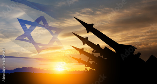 The missiles are aimed at the sky at sunset with Israel flag. Nuclear bomb, chemical weapons, missile defense, a system of salvo fire. photo