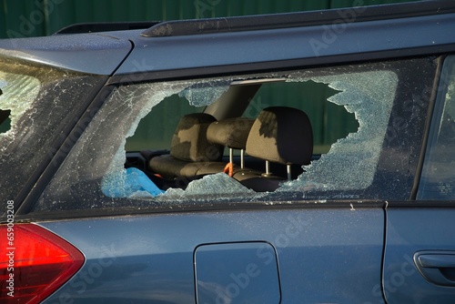 The broken shattered right hand side rear window on a vandalised automobile