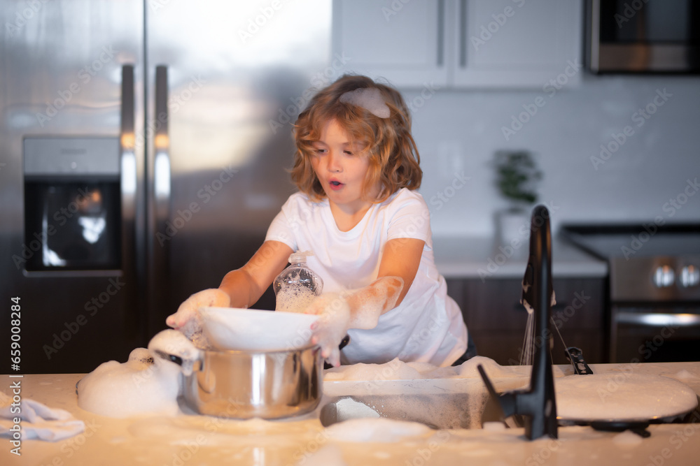 Funny twin boys helping in kitchen with washing dishes. Children having fun with housework. Little housekeeper. Child washing and wiping dishes in kitchen. Funny twin boys helping in kitchen with washing dishes. Children having fun with housework. Little housekeeper. Child washing and wiping dishes in kitchen.