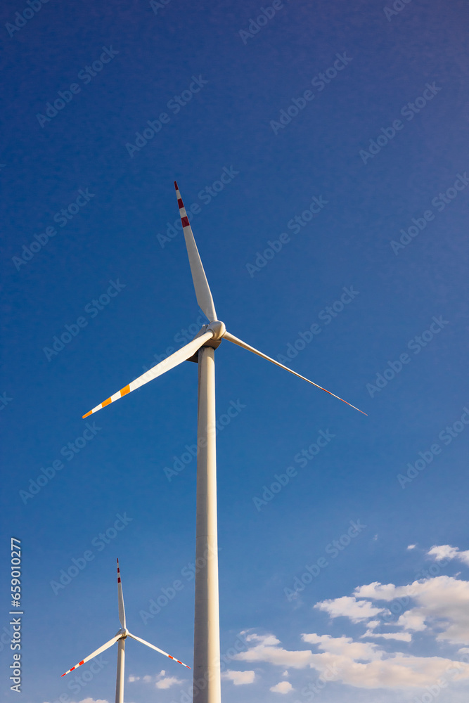 Windmill turbine with the blue sky on background