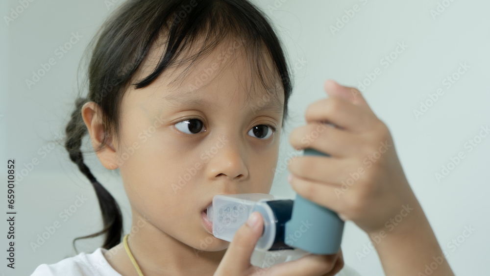 Asian girl uses inhaler during asthma and allergy attack Asian girl uses inhaler during asthma and allergy attack